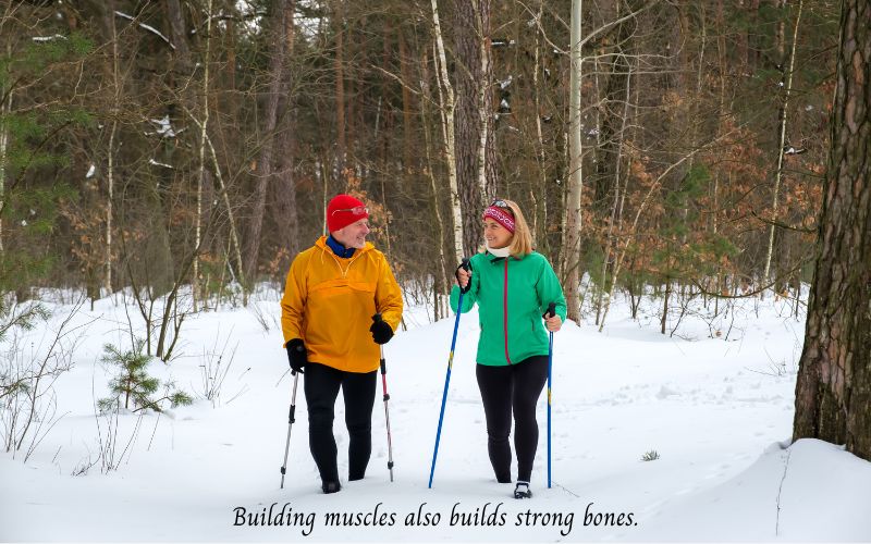 Building muscles also builds strong bones-a man and a woman walking in the woods using Nordic walking poles